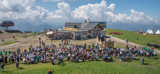 Viele Teilnehmer eines Chors vor der Corones Hütte am Kronplatz-Gipfel im Sommer. | © Skirama Kronplatz