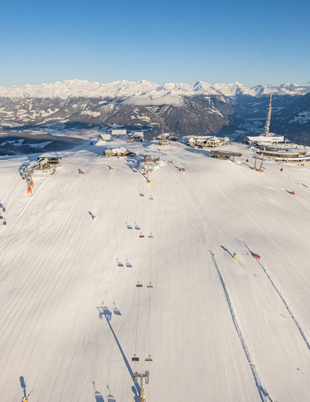 Weitläufige Skipisten mit Spuren im Schnee und umliegenden Bergen bei Tageslicht. | © Harald Wisthaler